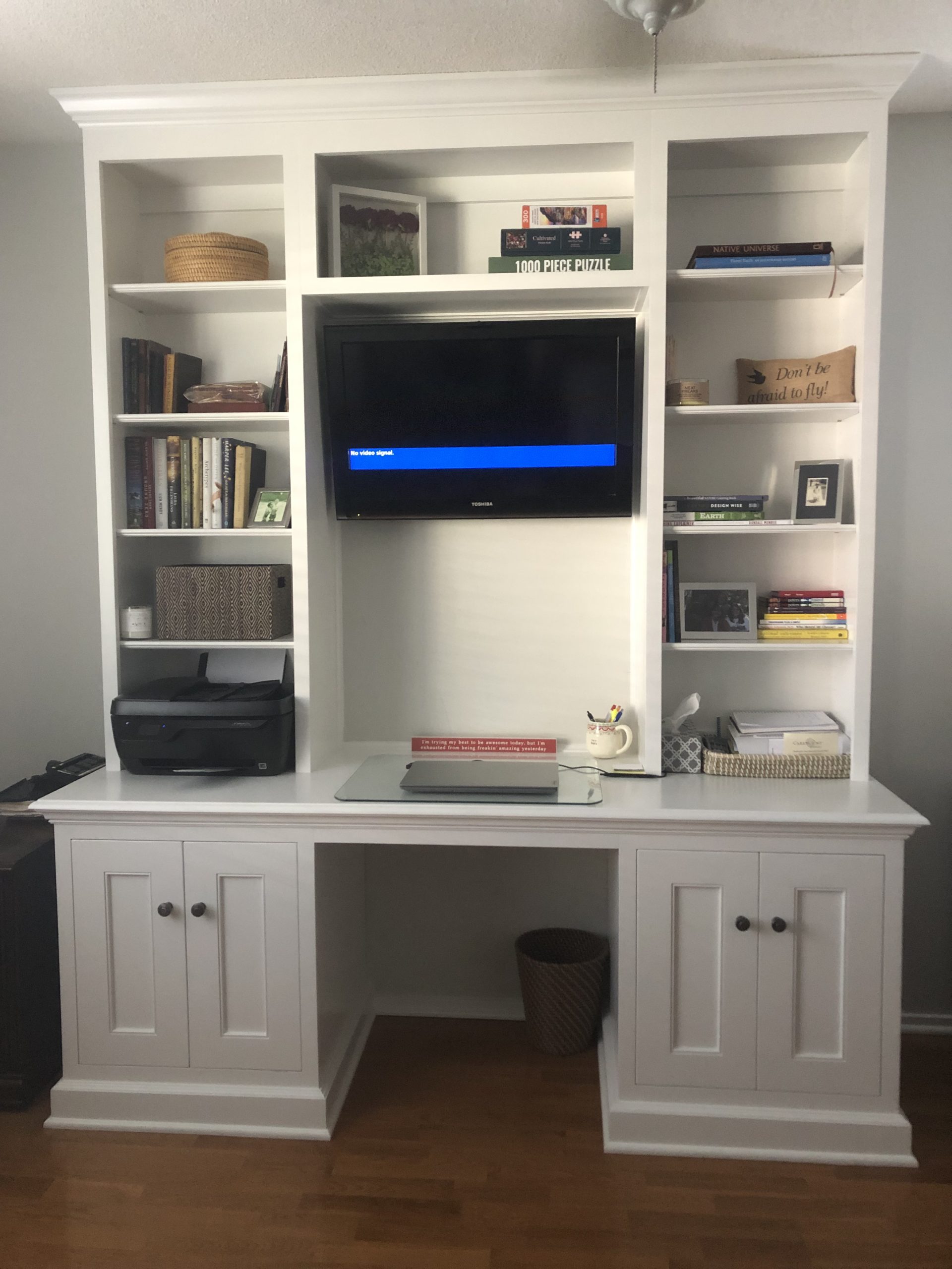Home office wall unit with space for a monitor, printer, laptop. with storage below and book or display shelves above.